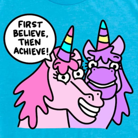 Cropped close-up of unicorn shirt in Heather Aqua showing playful cartoon unicorn and motivational “First Believe, Then Achieve.” design, by Kalirally.