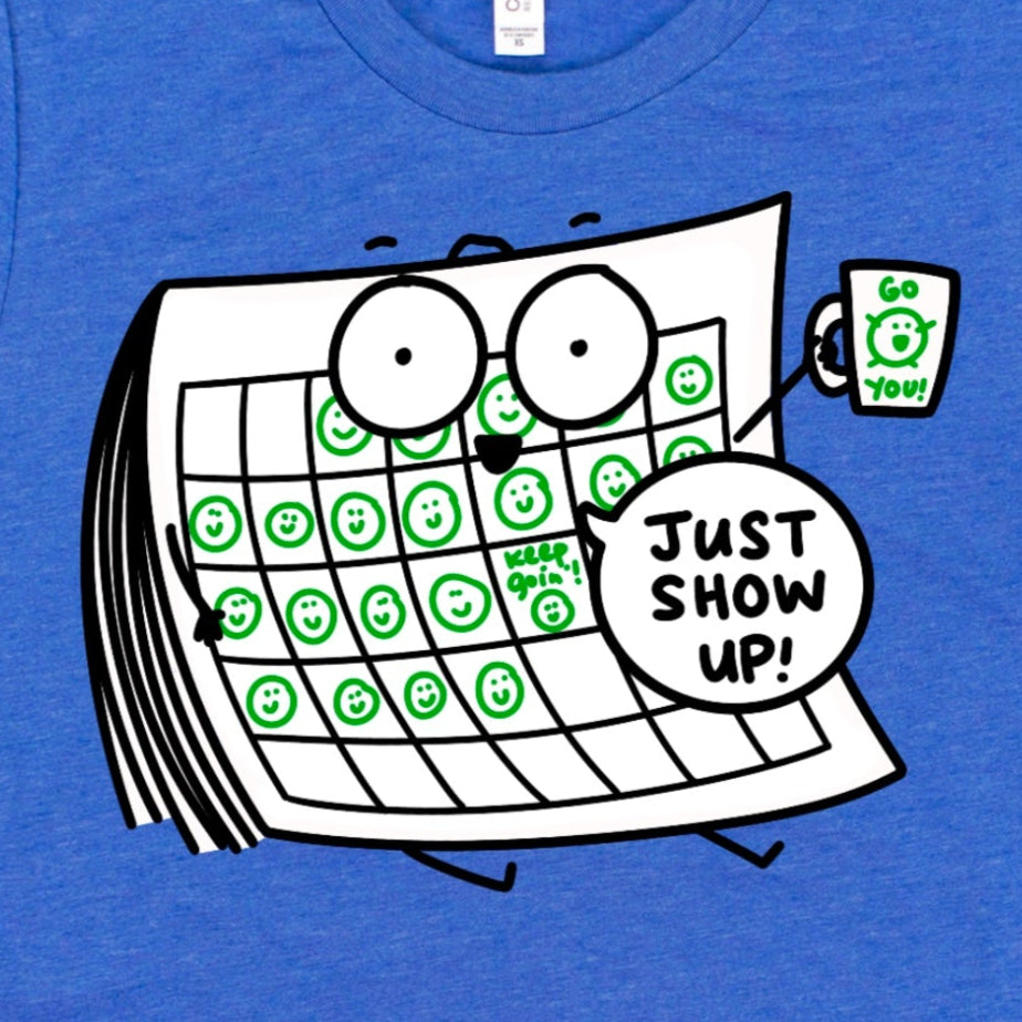 Close-up of Just Show Up Shirt design in Heather Royal Blue showing cartoon calendar with happy faces and coffee mug saying “Go you!”, by Kalirally