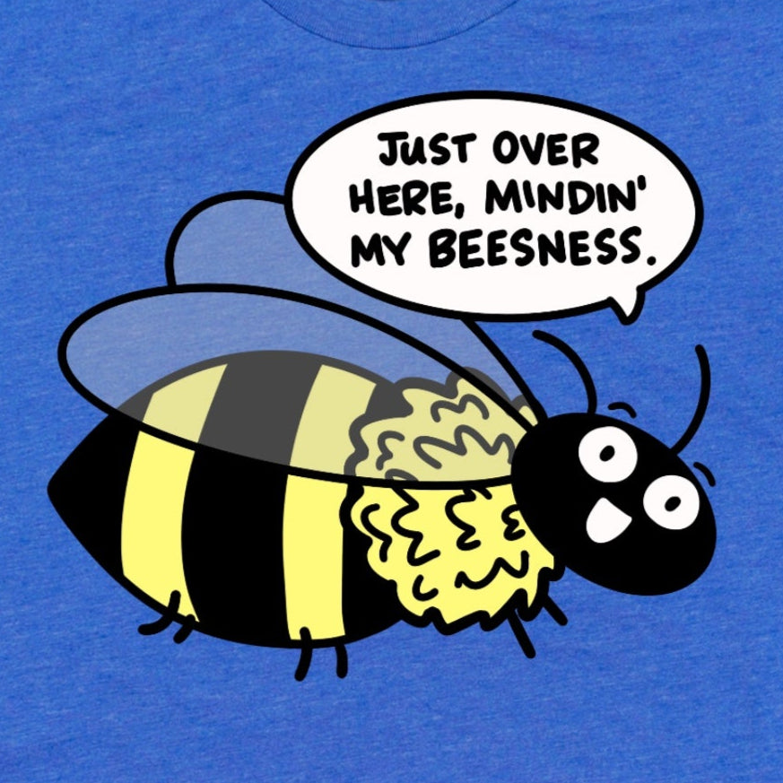 Close-up of cartoon bee and pun “Just Over Here Minding My Beesness” on heather true royal blue t-shirt, funny graphic tee by Kalirally