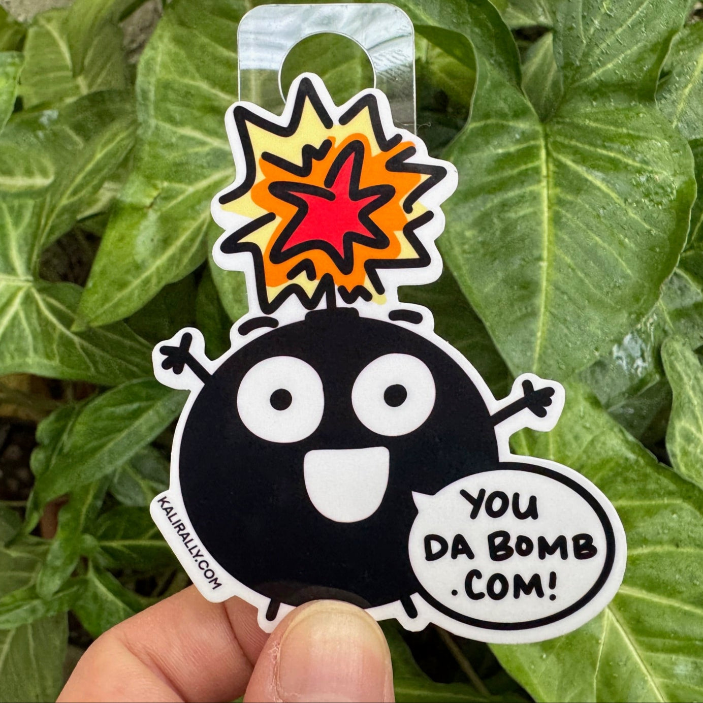 Cartoon compliment sticker with phrase “You da bomb dot com!” funny decal by Kalirally