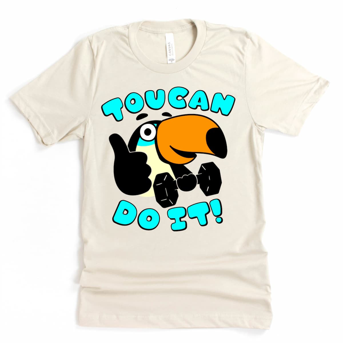 Heather dust shirt with a cartoon toucan cheering you on with a dumbbell and a grin. Just the tee in flat lay.