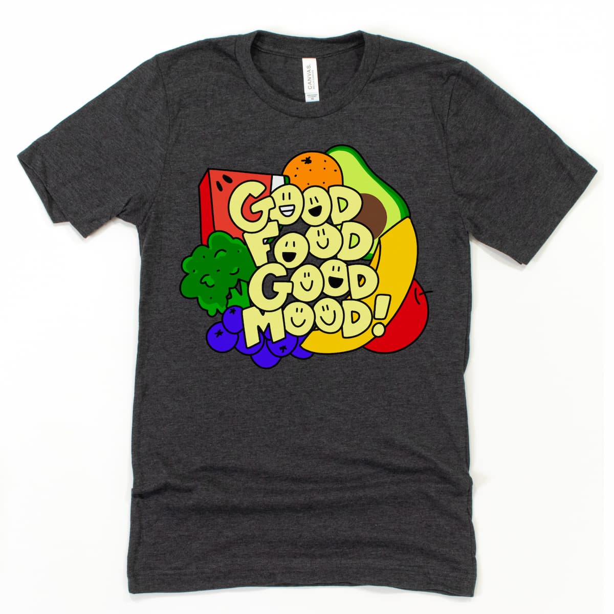 Flat lay of an athletic gray Good Food Good Mood T Shirt showing a vibrant lineup of fruits and veggies with playful typography, by Kalirally