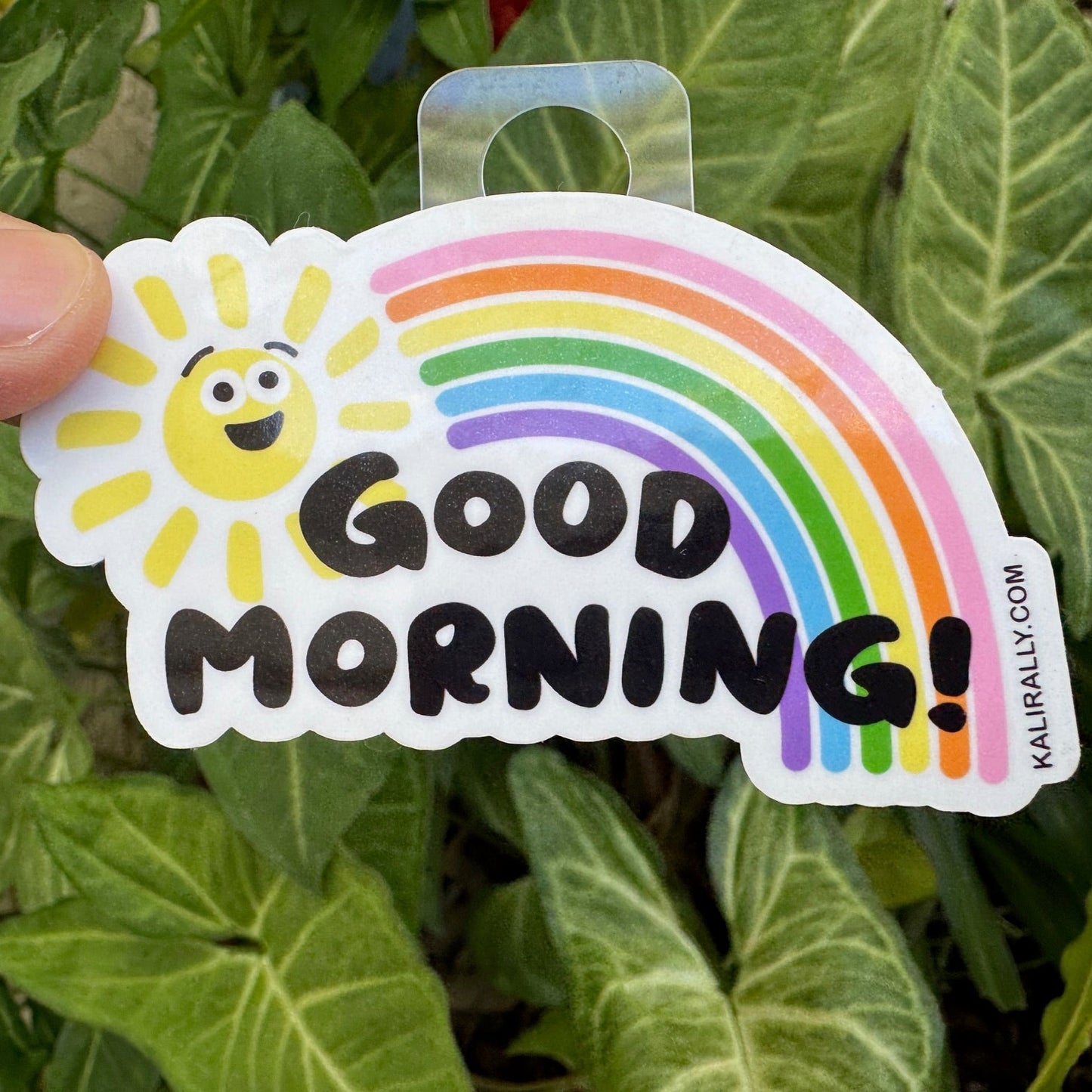 Good Morning Sticker with smiling cartoon sun and rainbow, cheerful positivity decal by Kalirally