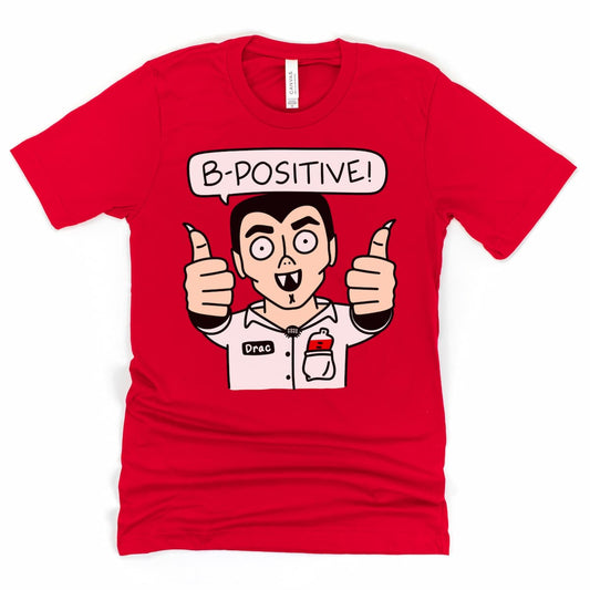 B-Positive Vampire Shirt in bold Red with cartoon vampire Drac managing a blood drive – perfect Halloween shirt for phlebotomists and blood donation fans.