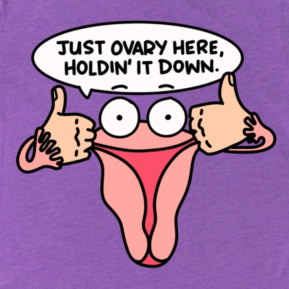 Close-up of Heather Purple Funny Ovary Shirt showing uterus cartoon with phrase “Just Ovary Here, Holdin’ It Down,” humorous feminist design by Kalirally