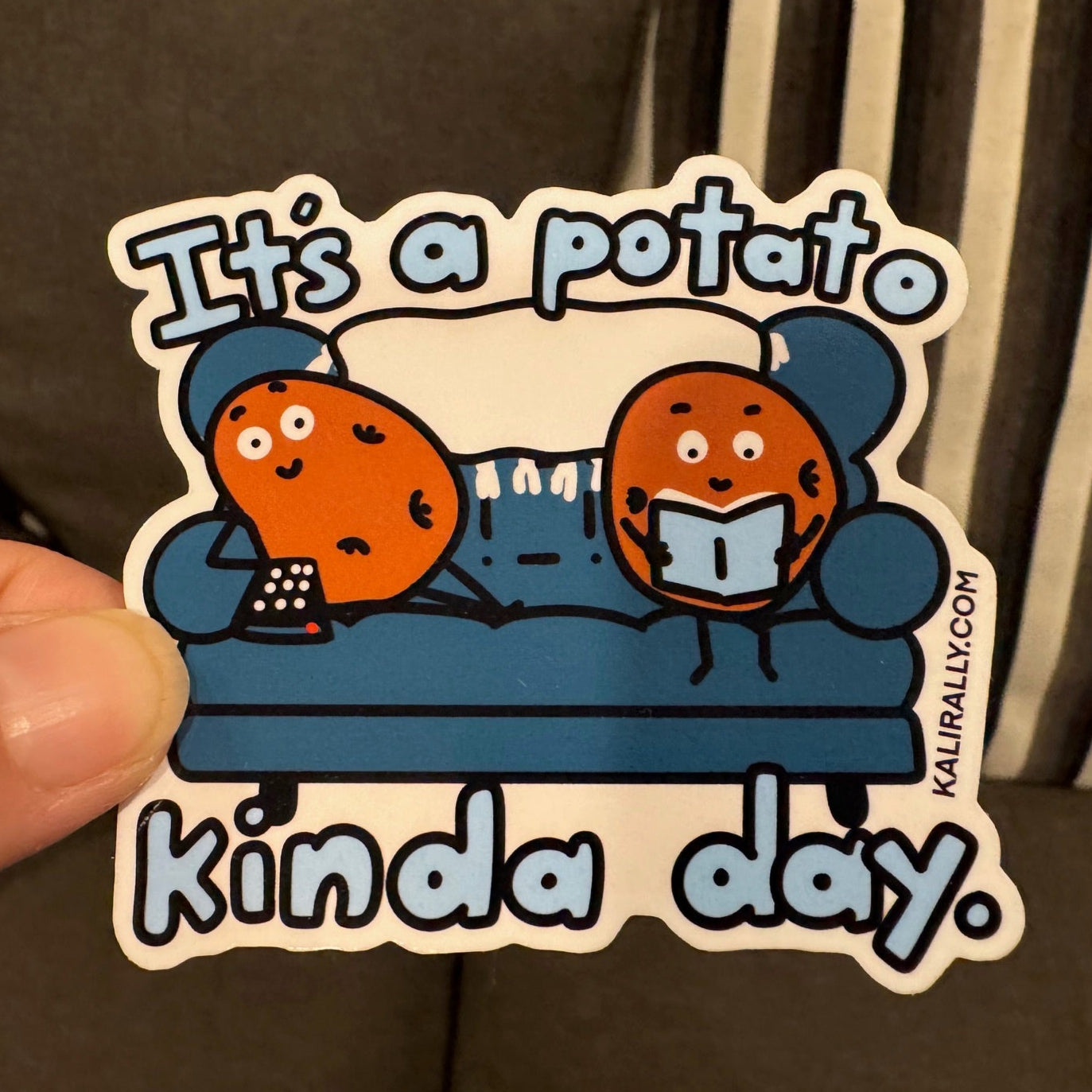 Couch Potato Sticker by Kalirally featuring “It’s a Potato Kinda Day” with a potato relaxing on a couch, watching TV and reading, glossy vinyl water bottle sticker, perfect for laptops, bottles, notebooks, and gifts.