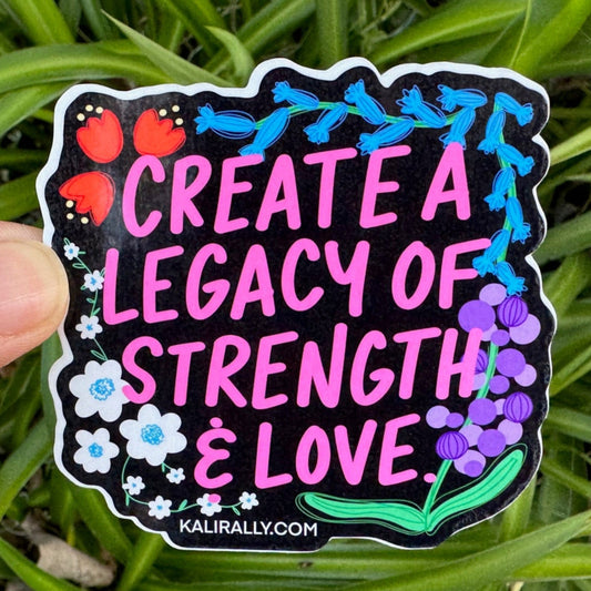 Glossy vinyl water bottle sticker by Kalirally featuring colorful florals on black and the quote “Create a Legacy of Strength and Love,” perfect for laptops, bottles, notebooks, and gifts.