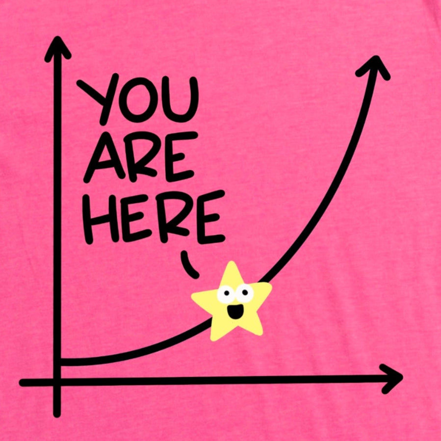 Close-up of exponential growth curve with star labeled “You Are Here” on heather charity pink shirt, motivational growth graphic tee by Kalirally