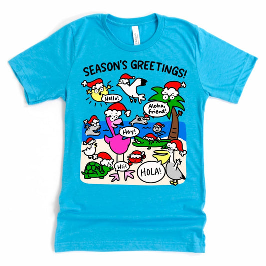 Florida Beach Christmas Tee in Heather Aqua with cartoon Santa, palm tree, sun, and local critters saying “Season’s Greetings!”, by Kalirally