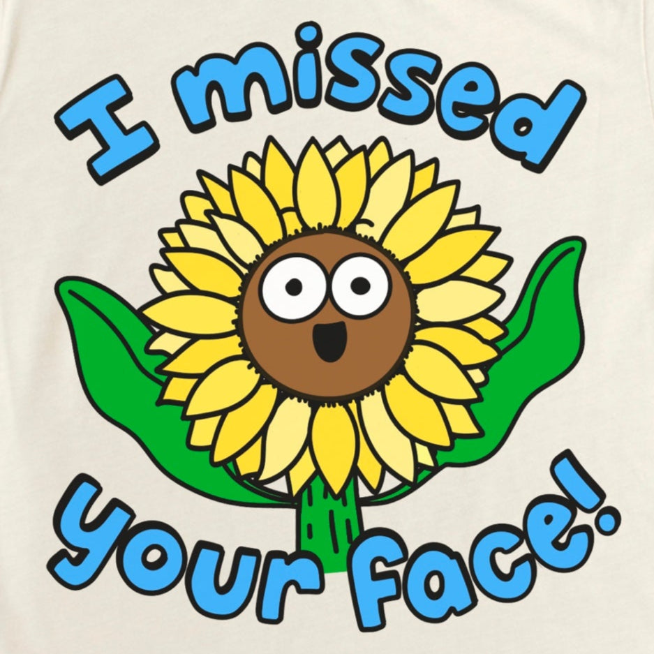 Beige t-shirt with a sunflower graphic and text 'I missed your face!' by Kalirally