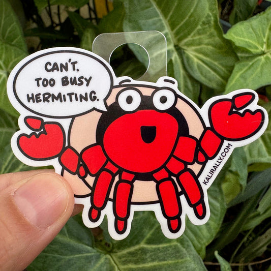 Sticker of a cartoon hermit crab with a speech bubble that says, "Can't, too busy hermitting." by Kalirally