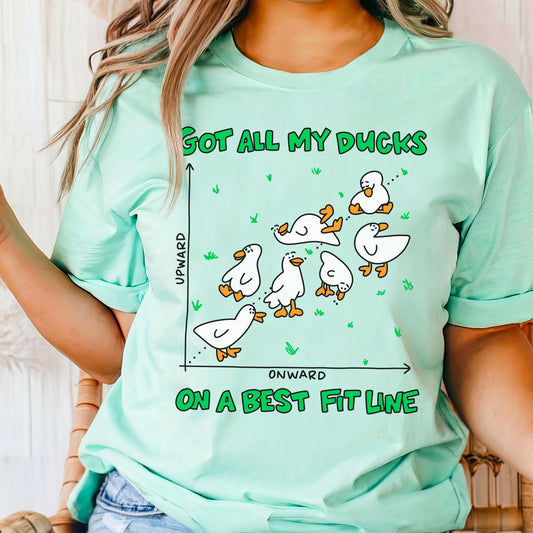 Funny math t-shirt featuring “Got all my ducks on a best fit line” design, shown in heather mint green on a woman. Great gift for math teachers, statisticians, and pun lovers.