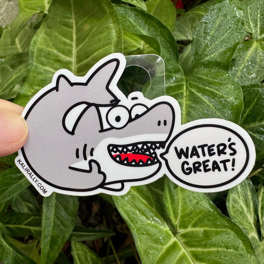 artoon great white shark sticker with the phrase “Water’s Great!” — funny waterproof vinyl beach decal for water bottles, laptops, and more, by Kalirally