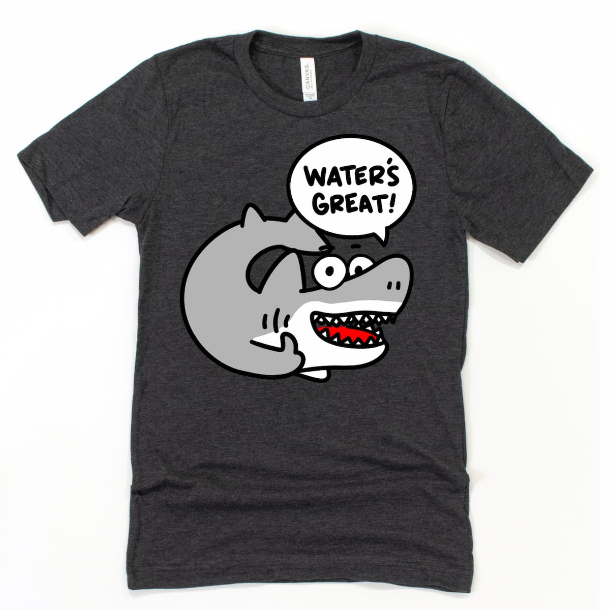 Flat lay of Kalirally shark t shirt in heather dark grey featuring a cartoon shark saying “Water’s great!” with playful beach vibes.