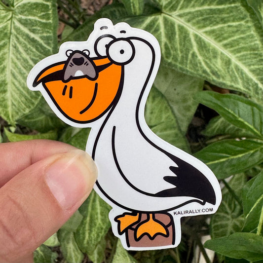 A picture of a Pelican Sticker with cartoon pelican and shark at the beach – playful ocean decal by Kalirally