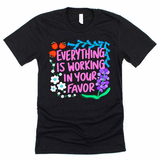 Positive affirmation shirt with “Everything is working in your favor” phrase in Heather Black by Kalirally