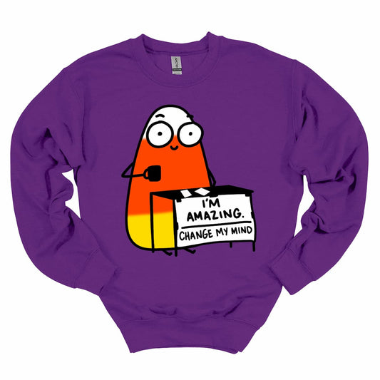Purple sweatshirt with cartoon candy corn and “I’m Amazing, Change My Mind” slogan — festive Halloween sweatshirt by Kalirally