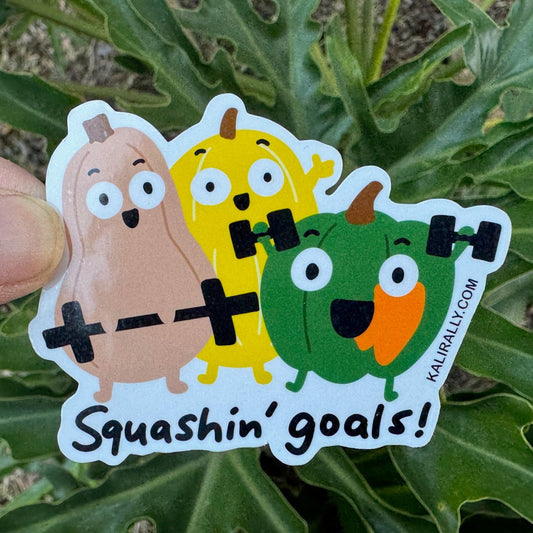 A picture of cute vinyl glossy sticker of three cartoon squashes lifting weights with “Squashin’ goals!” text, fun and cute gym sticker perfect for water bottles and workout gear, by Kalirally. 