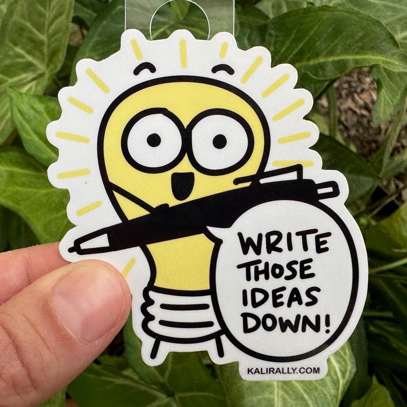 Writer Sticker with cartoon lightbulb and text “Write those ideas down!”, creative ideas decal by Kalirally.
