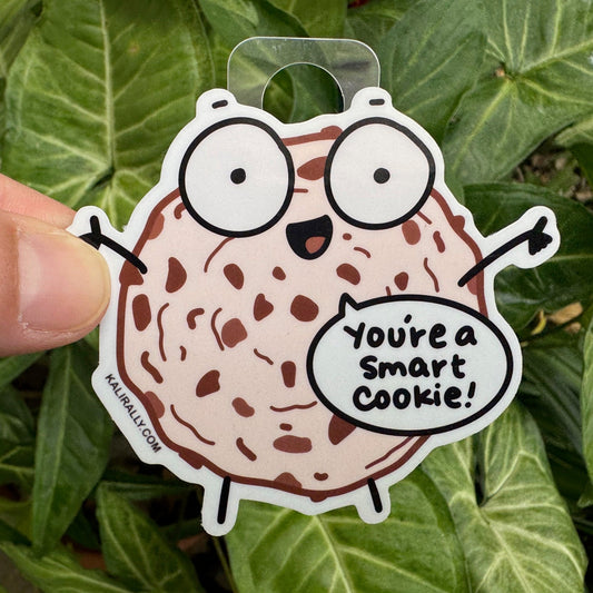 Smart cookie sticker featuring a cartoon chocolate chip cookie with a happy face and the phrase "You're a Smart Cookie!" Funny vinyl food decal for laptops and water bottles.